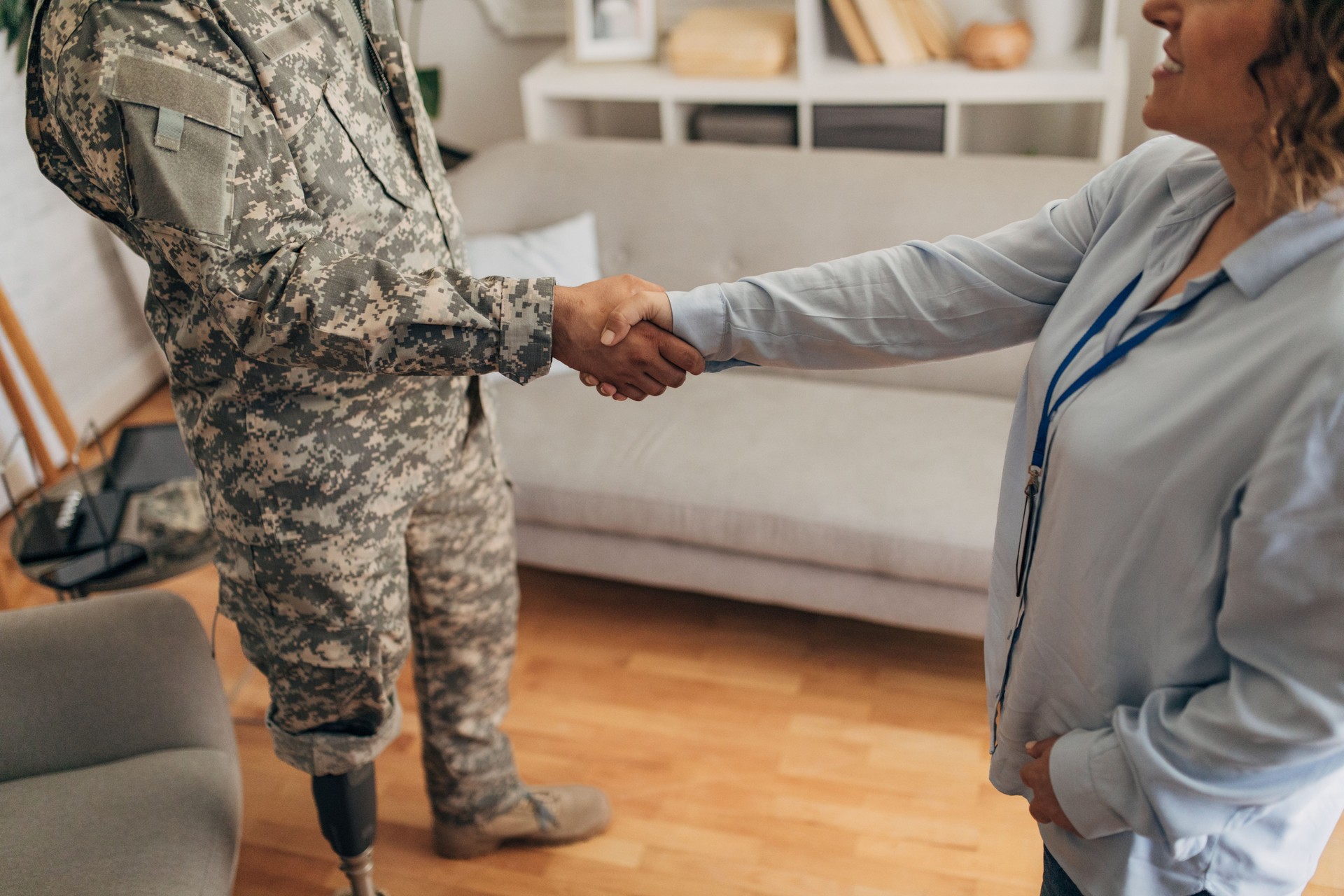 Therapist and veteran with prosthetic leg shaking hands